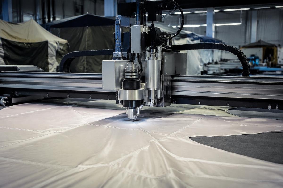 CNC oscillating knife cutting machine processing tent fabric on factory floor